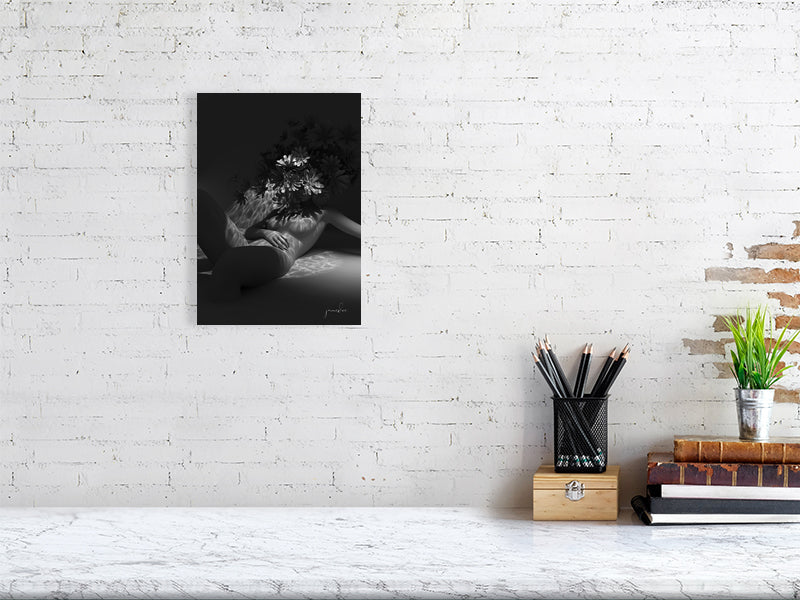 Modern framed digital art print on white brick wall above marble desk with plant and books.