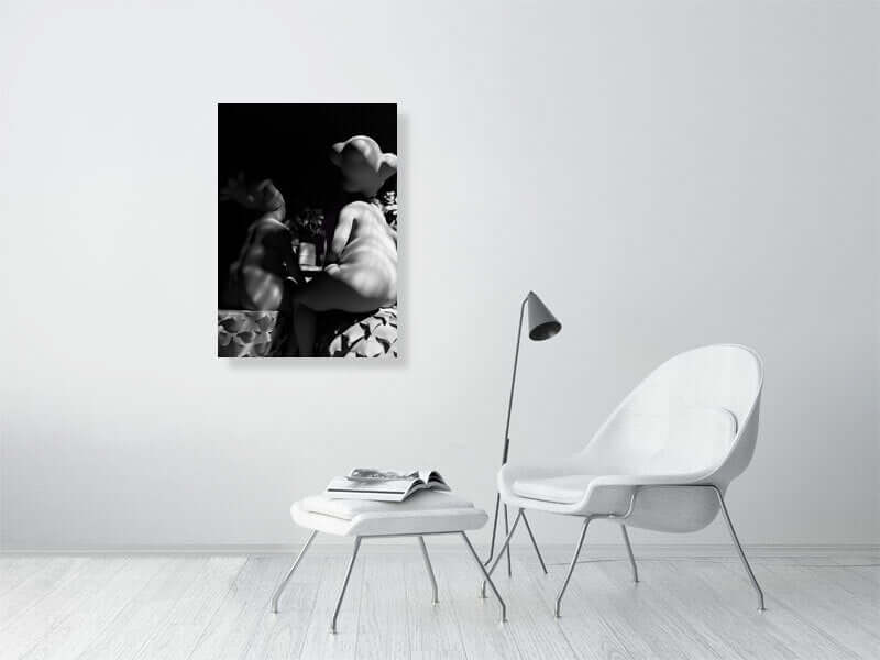 Modern living room with white furniture featuring a black and white digital art print on the wall.