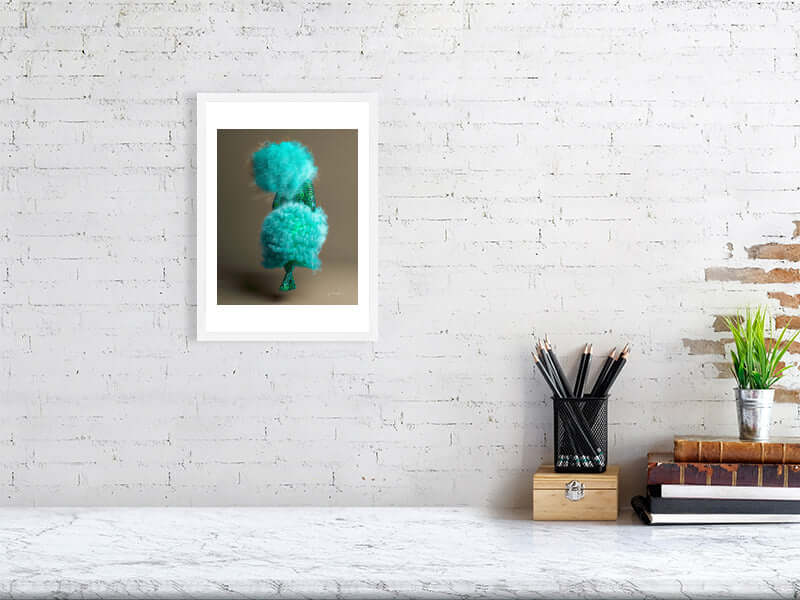 Framed digital art print titled "Puff" with trippy, modern design hung on white brick wall above a desk with stationary.