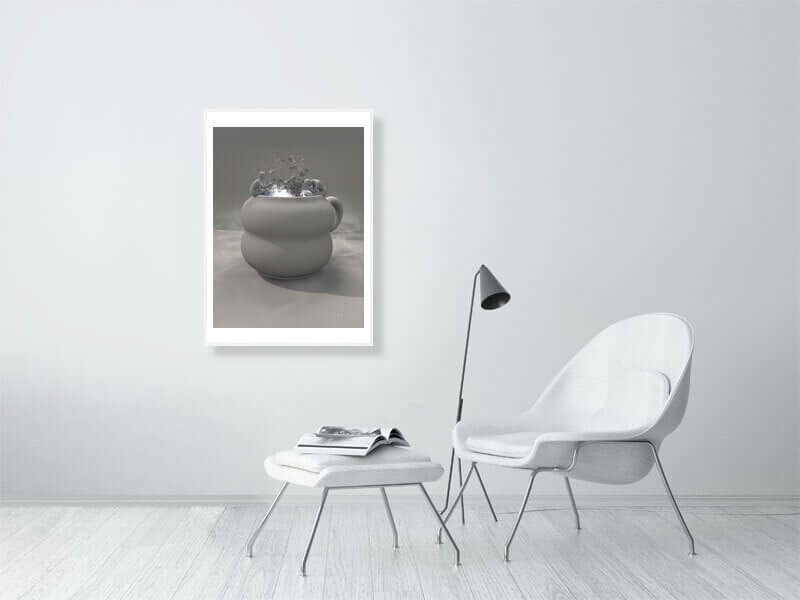 Modern living room with framed digital trippy art print of a clay cup on wall, white chair, and side table.