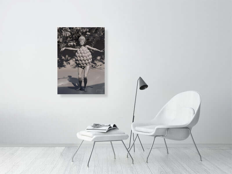 Modern living room with a black and white digital art print of a person in a bubble costume on the wall, beside a minimalist chair and table.